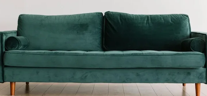Sitzflächen und Kissen eines grünen Stoffsofas